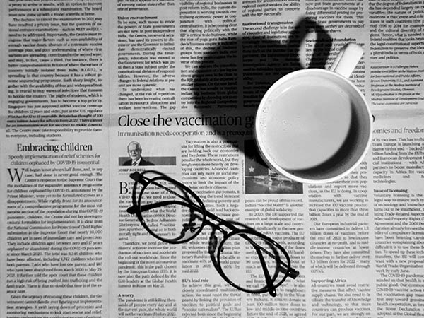 Glasses and a coffee mug sitting on a newspaper spread