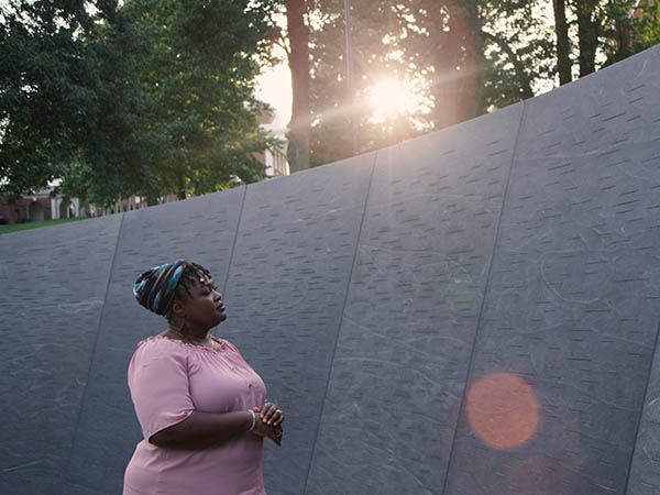African American women viewing the Memorial to Enslaved Laborers at UVA